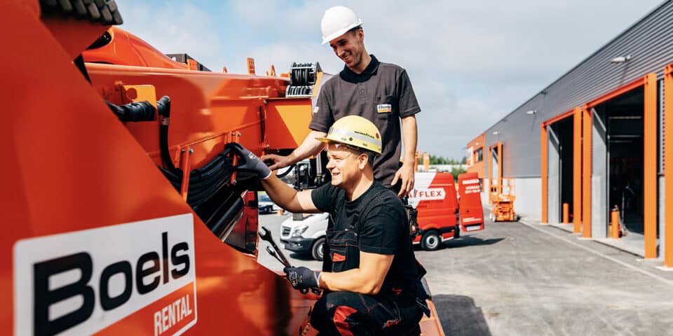 Zwei Mitarbeiter outdoor arbeiten an hydraulischem Gerät mit technischen Informationen